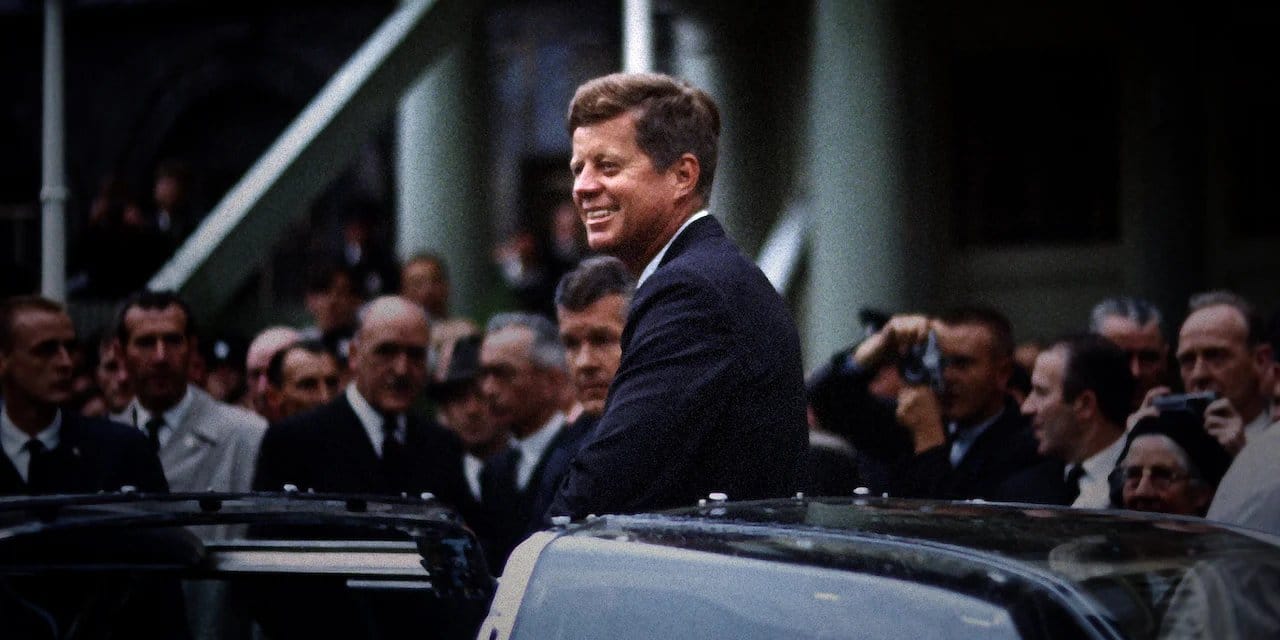 JFK Revisited: Through the Looking Glass backdrop