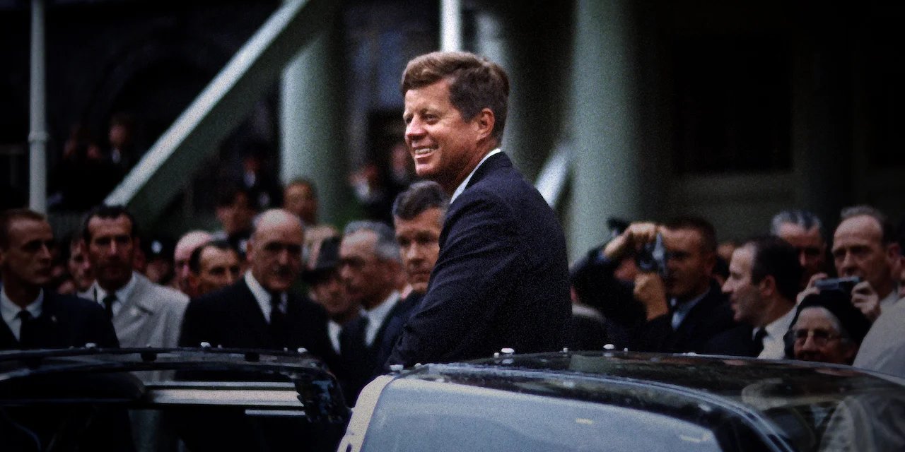 JFK Revisited: Through the Looking Glass backdrop